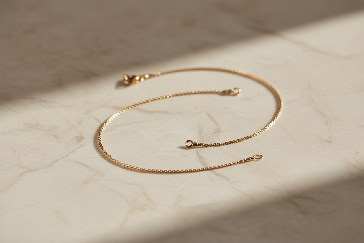 erstelle mir in PNG 1280 x 2000 eine goldene schlichte fußkette mit einem ästhetisch mit einem beigen marmor hintergrund